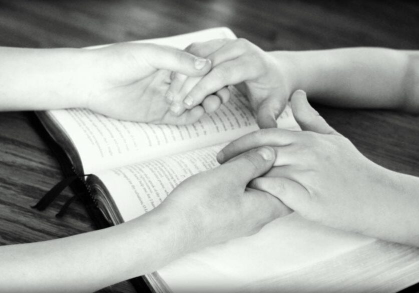 holding hands and reading the bible